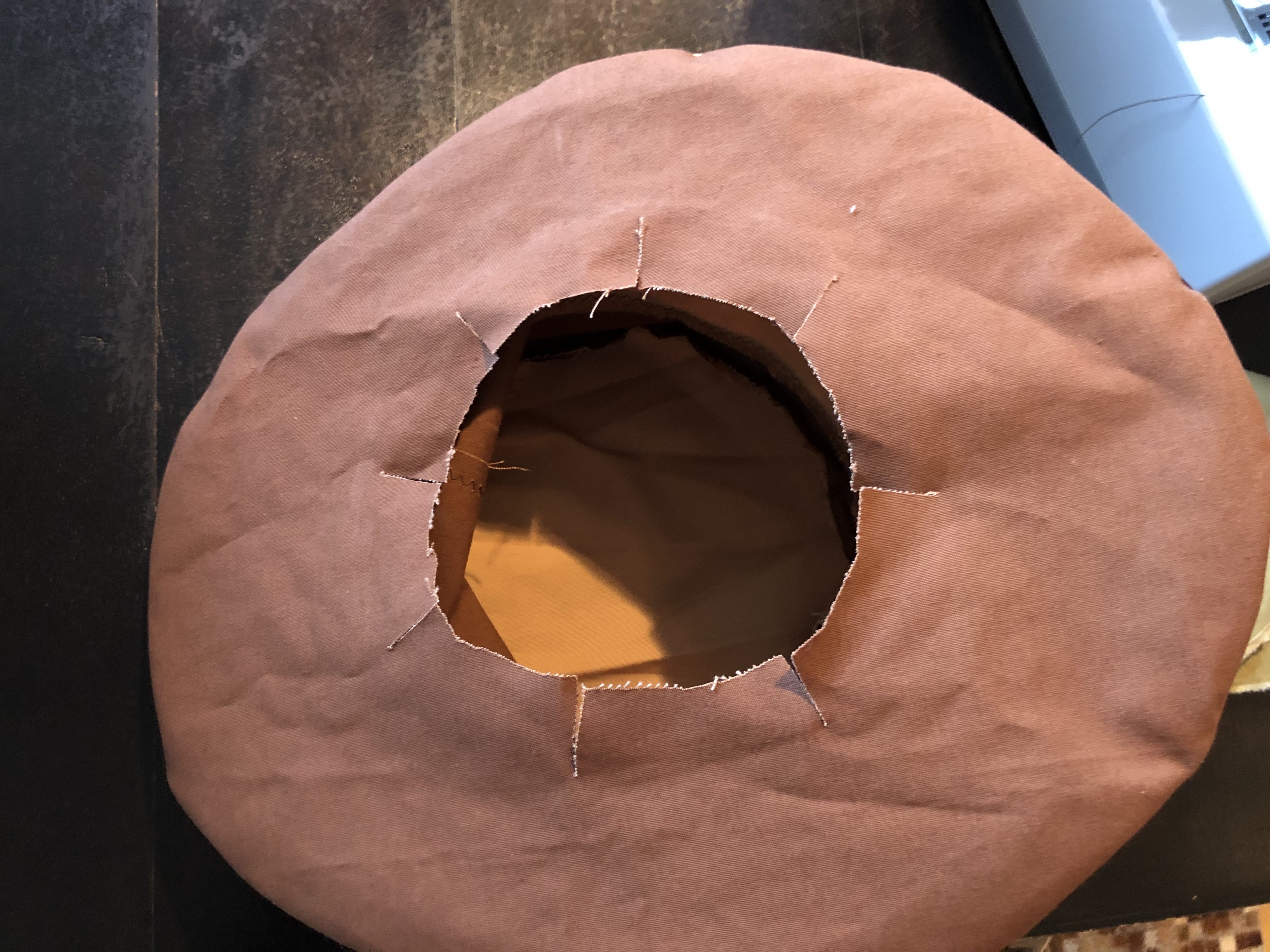 Make a smaller hole than your head and cut slits to measure...