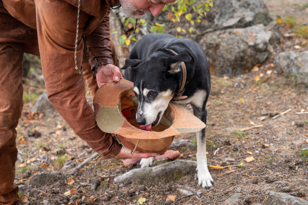 Tuiliq kayak jacket, pants and the dog Maja (RIP) drinking from hat in nature